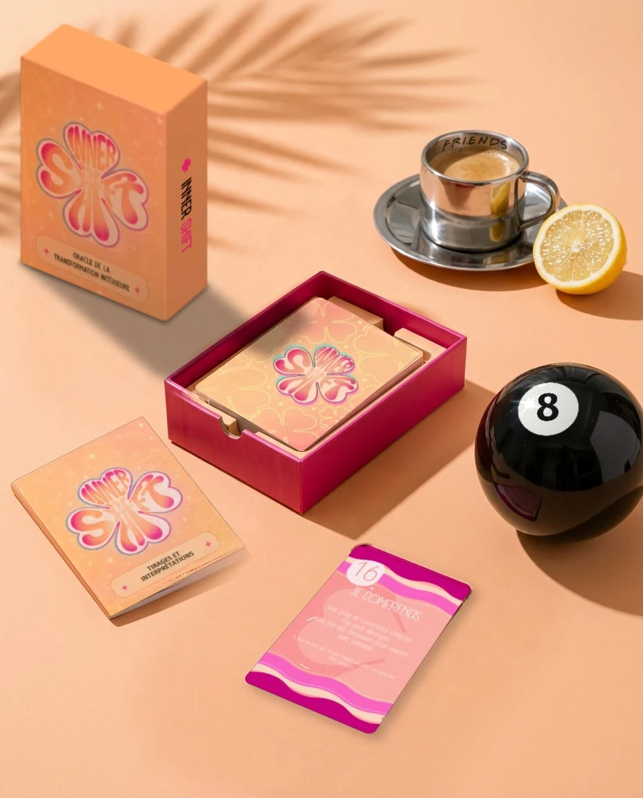 L'Oracle Inner Shift : boîte, livret et cartes posés sur une table pêche ensoleillée